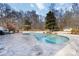 Outdoor pool with travertine tile surround, stone accents, and serene setting at 4001 Carmel Acres Dr, Charlotte, NC 28226