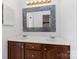 Bathroom featuring double sink vanity with framed mirror and wood cabinets at 4001 Carmel Acres Dr, Charlotte, NC 28226