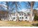 Stately white brick home featuring mature trees and a well-manicured lawn at 4001 Carmel Acres Dr, Charlotte, NC 28226