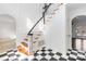 Elegant foyer features black and white tile, a staircase with wood treads, and white walls with wainscoting at 4001 Carmel Acres Dr, Charlotte, NC 28226