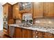 Close-up of the kitchen sink with granite countertops, wooden cabinets, and stainless steel appliances at 4001 Carmel Acres Dr, Charlotte, NC 28226