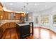 Bright kitchen featuring a kitchen island with granite countertops, wood cabinetry, and a bay window at 4001 Carmel Acres Dr, Charlotte, NC 28226