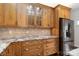 Close-up of the kitchen wooden cabinets, granite countertops, stainless steel refrigerator and backsplash at 4001 Carmel Acres Dr, Charlotte, NC 28226