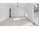 Empty living room featuring neutral carpet, fresh white paint, and natural light from large windows at 4001 Carmel Acres Dr, Charlotte, NC 28226