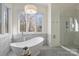 Modern bathroom with a freestanding tub, a large window, and a glass-enclosed shower at 4004 Blossom Hill Dr, Matthews, NC 28104