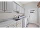 Clean and functional laundry room with white cabinetry, sink, and modern washer and dryer at 4004 Blossom Hill Dr, Matthews, NC 28104