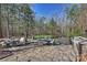 This outdoor patio features a built-in grilling area and dining set, surrounded by lush trees at 4004 Blossom Hill Dr, Matthews, NC 28104