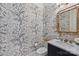 Elegant powder room features botanical wallpaper, bamboo mirror and marble countertop at 4004 Blossom Hill Dr, Matthews, NC 28104