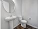 Half bath featuring pedestal sink, toilet and laminate flooring at 432 Burr St, Indian Trail, NC 28079