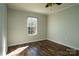 This bedroom has a ceiling fan and a large window letting in natural light with wood-look floors at 4428 Turkey Ln, Rock Hill, SC 29730