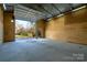 Garage interior with a concrete floor, plywood walls, and a large, open door at 4428 Turkey Ln, Rock Hill, SC 29730