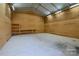 Spacious garage interior with concrete floor, plywood walls, overhead lighting and shelving at 4428 Turkey Ln, Rock Hill, SC 29730