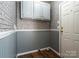 Laundry room featuring faux brick walls, wainscotting, overhead cabinets, and wood-look floors at 4428 Turkey Ln, Rock Hill, SC 29730