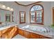 Elegant bathroom with marble vanity, soaking tub, and large windows at 6020 Havencrest Nw Ct, Concord, NC 28027