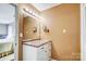 Bathroom vanity featuring a large mirror with vanity lighting and marble-look countertop with storage drawers at 7707 Ritter Dr, Charlotte, NC 28270