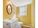 Bright bathroom featuring a vanity, oval mirror, and a window providing natural light at 7707 Ritter Dr, Charlotte, NC 28270