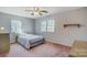 Bright bedroom with soft carpet, two windows, ceiling fan, and ample natural light at 7707 Ritter Dr, Charlotte, NC 28270