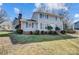 Two-story home featuring blue shutters, brick chimney, and meticulously maintained landscaping at 7707 Ritter Dr, Charlotte, NC 28270