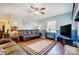 Comfortable living room featuring a large sofa, modern ceiling fan, and neutral rug on hardwood style flooring at 7707 Ritter Dr, Charlotte, NC 28270