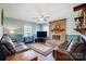 Inviting living room with a brick fireplace, ceiling fan, and comfortable seating on hardwood style floors at 7707 Ritter Dr, Charlotte, NC 28270