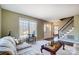 Inviting living room featuring large windows, a staircase, and hardwood floors at 7707 Ritter Dr, Charlotte, NC 28270