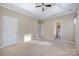 Bright main bedroom featuring a ceiling fan, neutral carpet, and an attached ensuite bathroom at 781 Woodlawn Ave, Mount Holly, NC 28120