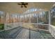 This screened porch features outdoor living with a patterned rug and ceiling fan for warm days and evenings at 781 Woodlawn Ave, Mount Holly, NC 28120