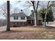 Charming two-story brick home featuring green shutters, black front door, and a well-maintained front yard at 8025 Cliffside Dr, Charlotte, NC 28270