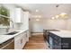 Modern kitchen with white cabinets, stainless steel appliances, and a large island with cooktop at 8025 Cliffside Dr, Charlotte, NC 28270