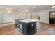 Kitchen island with cooktop, white countertops, and pendant lighting at 8025 Cliffside Dr, Charlotte, NC 28270