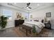 Bright bedroom features a tufted headboard, tray ceilings, two windows, and stylish dark wood furnishings at 8348 Acadia Pkwy, Sherrills Ford, NC 28673