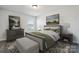 Well-lit bedroom featuring a plush bed, stylish gray furniture and artwork that adds a touch of elegance to the room at 8348 Acadia Pkwy, Sherrills Ford, NC 28673