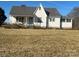 Charming exterior of a home featuring a covered front porch and a well-maintained lawn under a clear blue sky at 897 Mocksville Hwy, Statesville, NC 28625