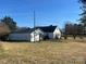 Exterior view of the house and the garage showcasing the backyard with a well-maintained lawn at 897 Mocksville Hwy, Statesville, NC 28625