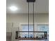 Modern chandelier with wood frame and metal accents hangs above, complementing kitchen design at 105 N Inman Ave, Bessemer City, NC 28016