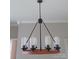 Stylish chandelier with glass shades and a wooden ring base adds warmth to the room's ambiance at 105 N Inman Ave, Bessemer City, NC 28016