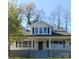 Charming two-story home featuring a covered front porch and classic black shutters against a bright white facade at 105 N Inman Ave, Bessemer City, NC 28016