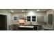 Well-lit kitchen featuring white subway tile backsplash, granite countertops, and gray cabinets at 105 N Inman Ave, Bessemer City, NC 28016