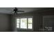 Bright living room featuring a ceiling fan and large windows for natural light at 105 N Inman Ave, Bessemer City, NC 28016