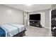 Comfortable bedroom featuring modern gray walls, wood floors, and a big screen tv at 107 Deese Ct, Indian Trail, NC 28079