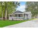 Charming gray home with a welcoming porch and landscaped front yard and gravel driveway at 107 Deese Ct, Indian Trail, NC 28079