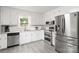 Bright kitchen featuring stainless steel appliances, gray counters, and ample white cabinetry at 107 Deese Ct, Indian Trail, NC 28079