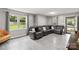 Spacious living room featuring gray luxury vinyl flooring, neutral walls, and large windows at 107 Deese Ct, Indian Trail, NC 28079