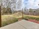 Large, partially fenced backyard with a concrete patio and fire pit, perfect for outdoor entertaining at 1128 Tangle Ridge Se Dr, Concord, NC 28025