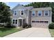 Charming two-story home with attached garage, well-maintained lawn, and mature landscaping at 1128 Tangle Ridge Se Dr, Concord, NC 28025