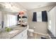 Bright bathroom with a granite countertop, a toilet, a shower with white curtain and shelves for ample storage at 1140 Roberts St, China Grove, NC 28023