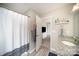 Clean bathroom featuring a granite countertop vanity, a shower with white curtain, and an open doorway to the main bedroom at 1140 Roberts St, China Grove, NC 28023