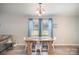 Cozy dining area features a rustic wooden table, white chairs, and light blue curtains for an inviting atmosphere at 1140 Roberts St, China Grove, NC 28023