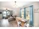 Bright living room featuring a sectional sofa and a rustic dining table illuminated by natural light at 1140 Roberts St, China Grove, NC 28023