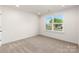 Bright bedroom with plush carpeting and a large window offering a pleasant neighborhood view at 118 I K Beatty St, Charlotte, NC 28214